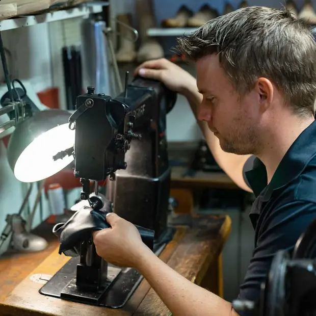 Felix Griesmann bei der Schuhreparatur in seiner Werkstatt in Schwangau